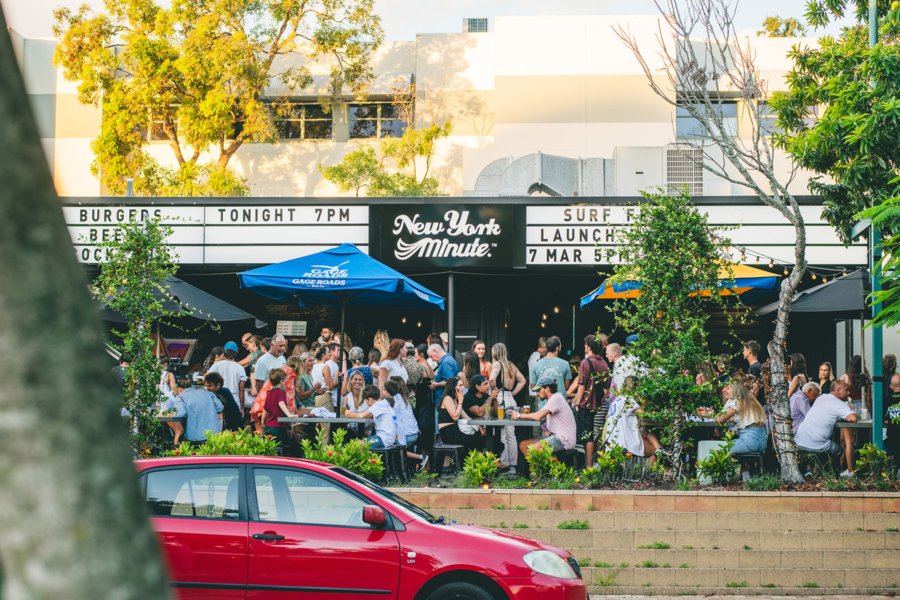 A crowded restaurant with the outside seating area full of people eating