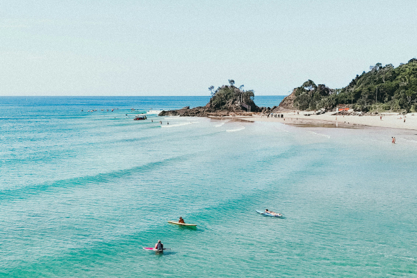 aerial view of the ocean with surfers and waves and the beach in the background