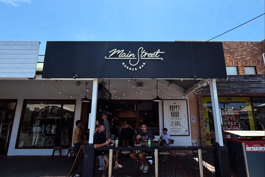 Exterior shot of a restaurant with people sitting outside and blue skies in the background