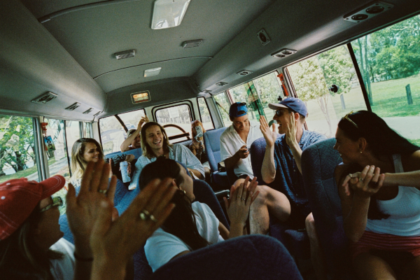 a group of backpackers laughing and having fun on a crowded JOEY bus