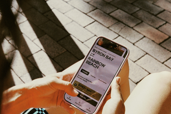 someone using their mobile phone to book a trip on the Joey bus