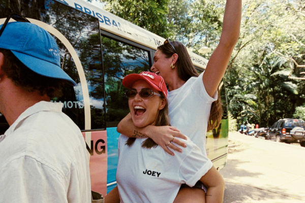 two people in joey tshirts giving piggybacks and getting on the bus